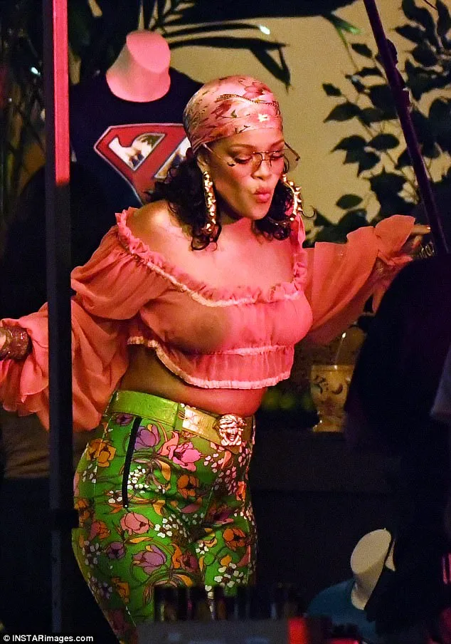 Η Rihanna με ροζ crop top και εμπριμέ πράσινο παντελόνι.
