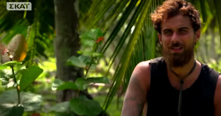 Παίκτης του Survivor με μούσια σε τροπικό περιβάλλον.