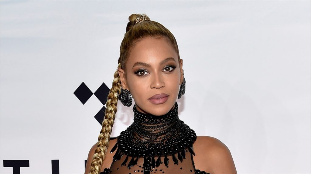 Η Beyoncé με ψηλή πλεξούδα και μαύρο φόρεμα με χάντρες.