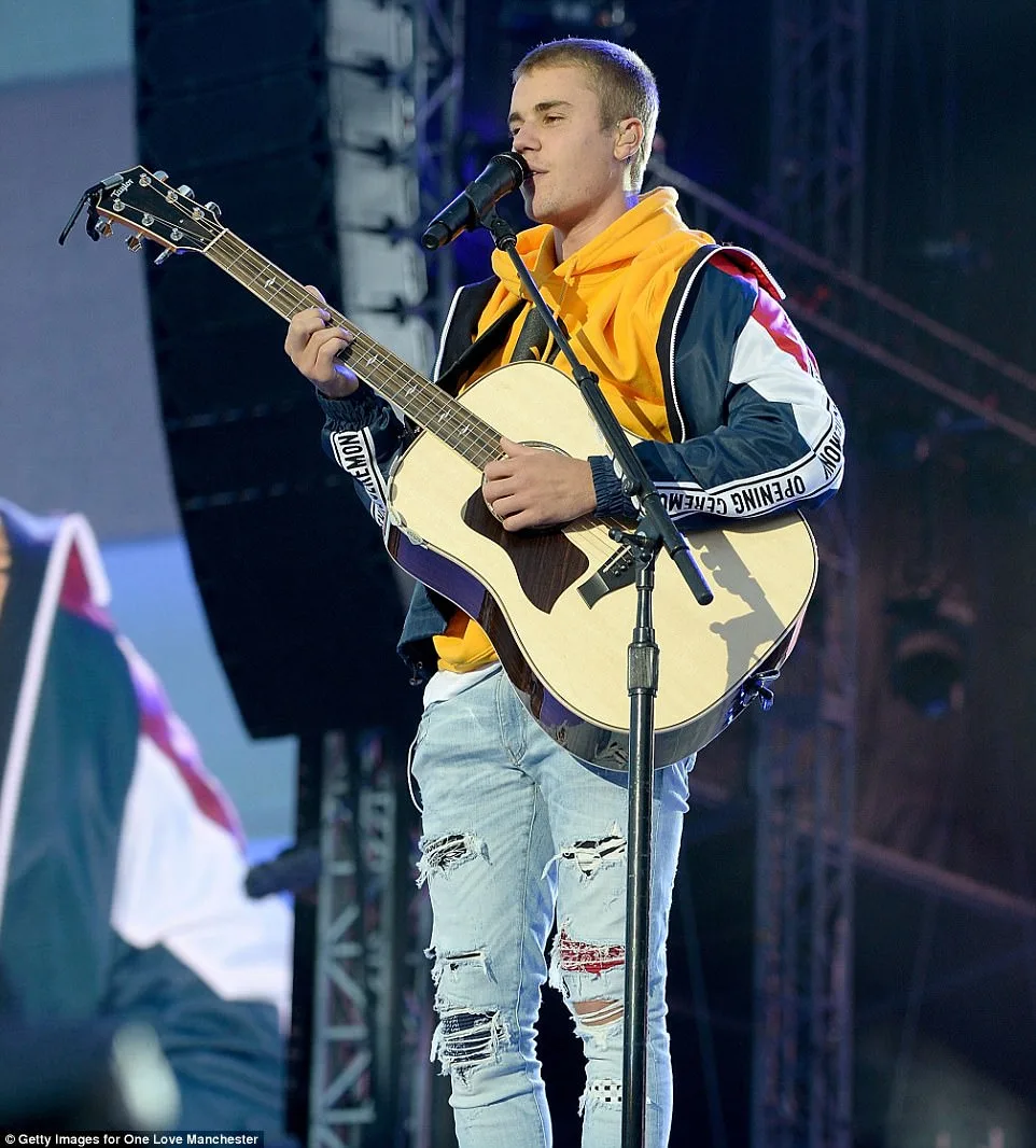Ο Justin Bieber παίζει ακουστική κιθάρα στη σκηνή του One Love Manchester.