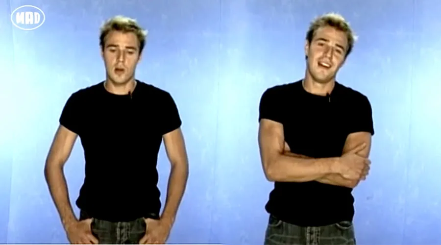 Παρουσιαστής του MAD TV σε διπλό πλάνο με μαύρο t-shirt και τζιν παντελόνι.