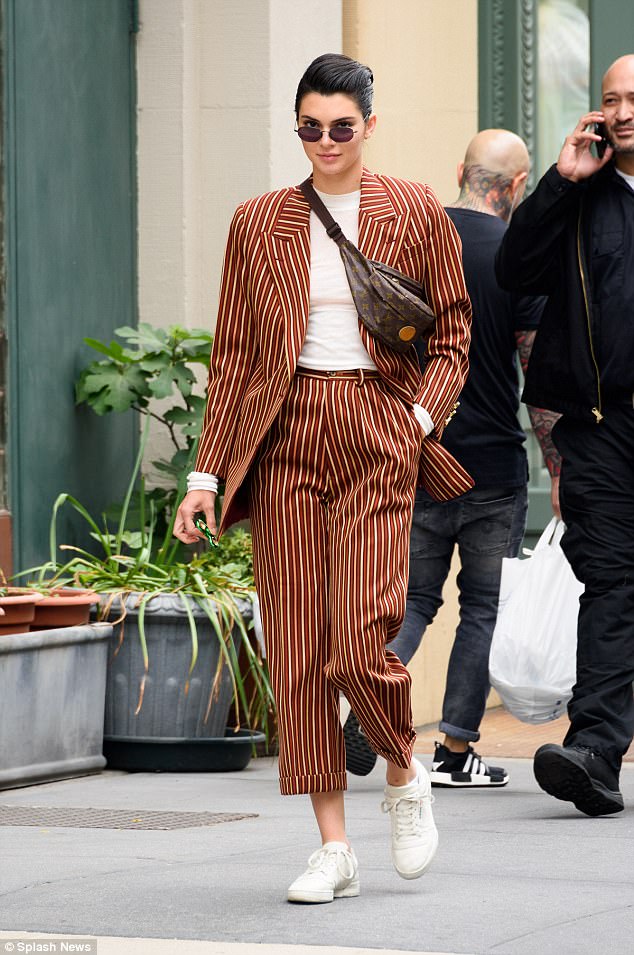 Η Kendall Jenner με ριγέ κοστούμι και τσαντάκι μέσης στο δρόμο.