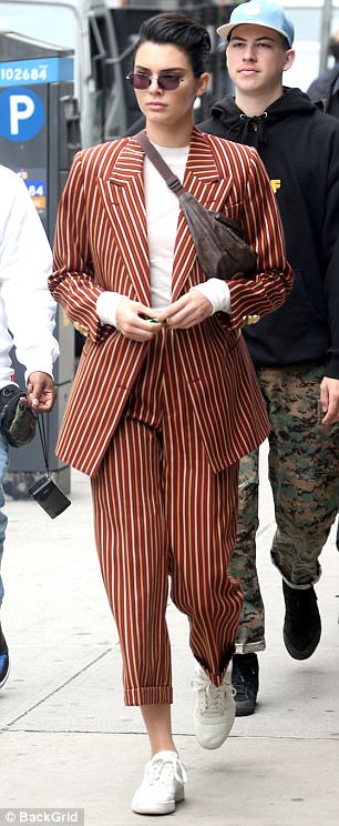 Η Kendall Jenner με ριγέ κοστούμι και fidget spinner στο χέρι.