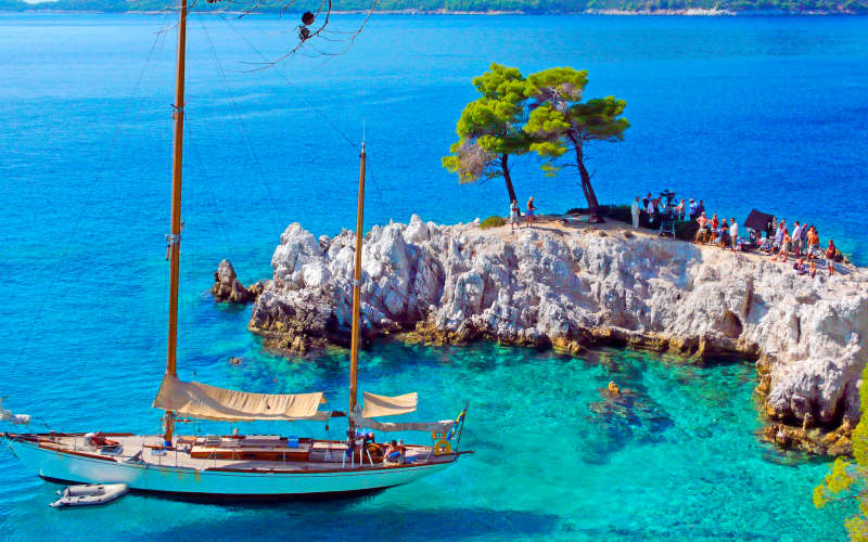 Σκηνή από τα γυρίσματα του sequel του Mamma Mia σε πανέμορφο ελληνικό νησί με ιστιοφόρο και συνεργείο.