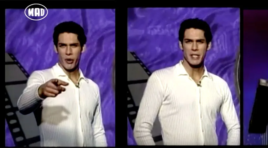 Παρουσιαστής του MAD TV σε τηλεοπτικό πλατό με μωβ φόντο.