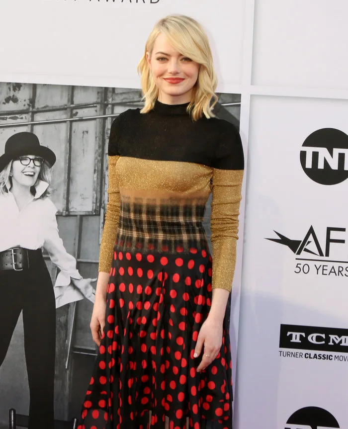 Η Emma Stone με ξανθά μαλλιά και πολύχρωμο φόρεμα σε εκδήλωση.