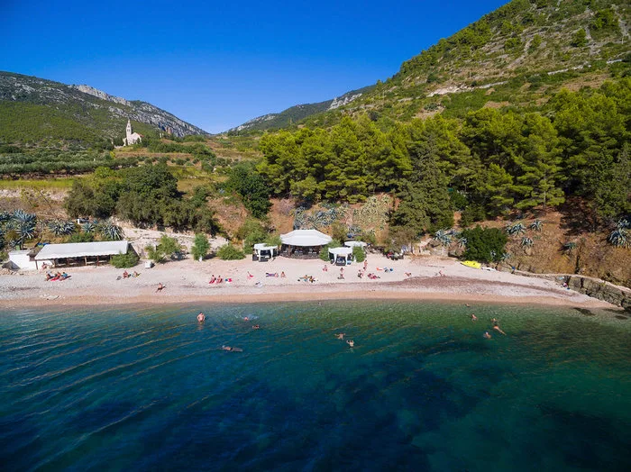 Παραλία στην Κροατία όπου γυρίστηκε το sequel του Mamma Mia, όχι στην Ελλάδα, με καταπράσινα βουνά και γαλαζοπράσινα νερά.