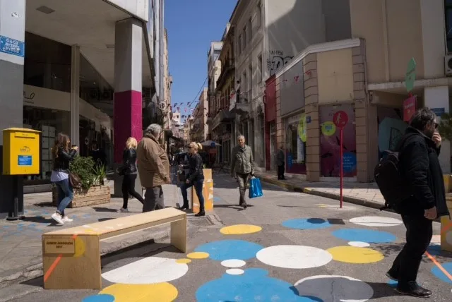 Πεζόδρομος στο κέντρο της Αθήνας με χρωματιστούς κύκλους και πεζούς.
