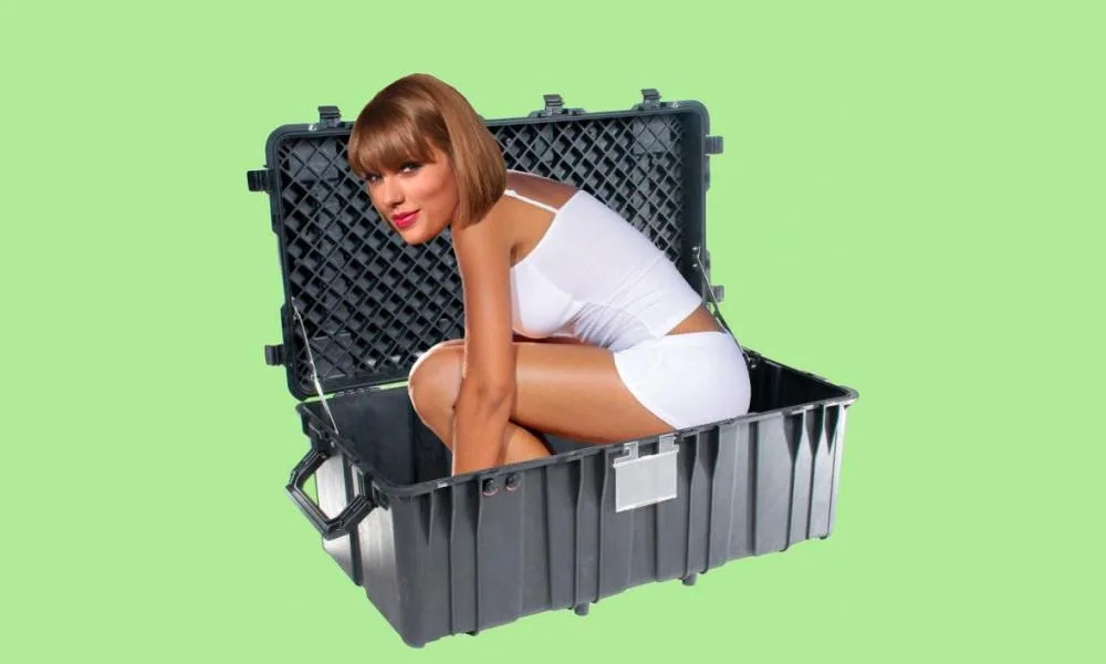 Η Taylor Swift μέσα σε μια μεγάλη μαύρη βαλίτσα.
