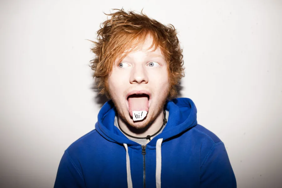 Ο Ed Sheeran με την γλώσσα έξω και ένα χαρτάκι που γράφει hi!
