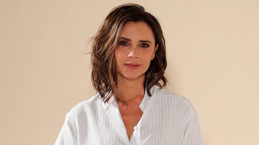 Η Victoria Beckham ποζάρει με ριγέ πουκάμισο.