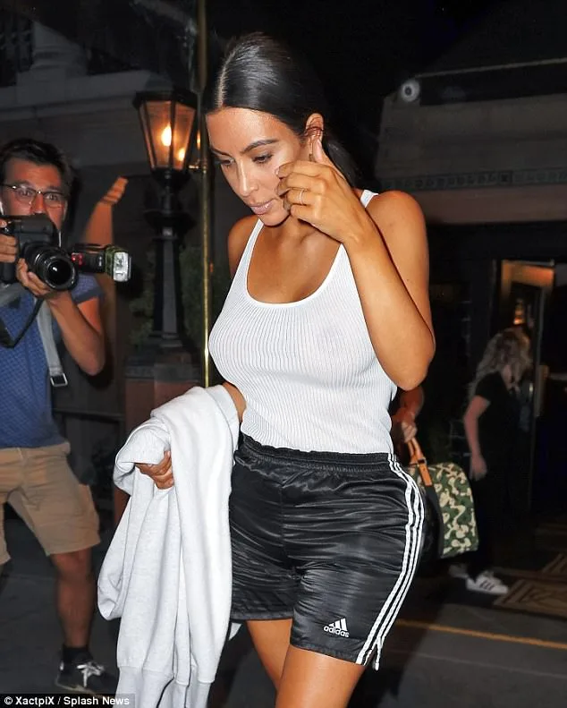 Η Kim Kardashian με λευκό φανελάκι και μαύρο αθλητικό σορτς Adidas.