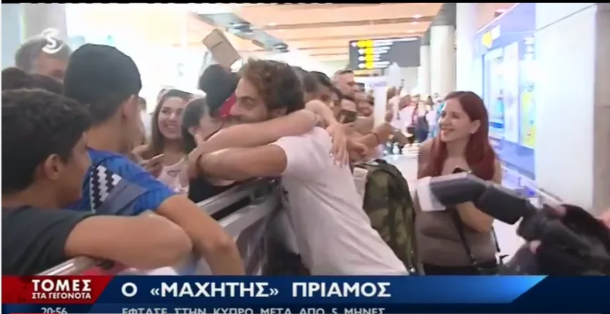 Ο Μάριος Πρίαμος Ιωαννίδης αγκαλιάζει θαυμαστές στο αεροδρόμιο.