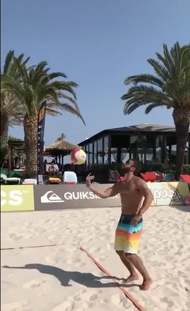 Ο Κωνσταντίνος Βασάλος παίζει beach volley σε παραλία.