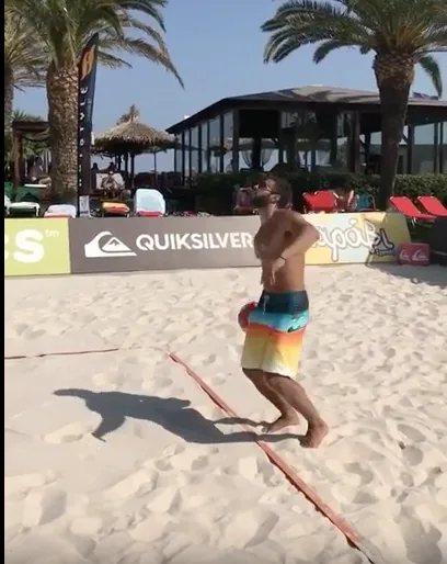 Ο Κωνσταντίνος Βασάλος παίζει beach volley σε παραλία.