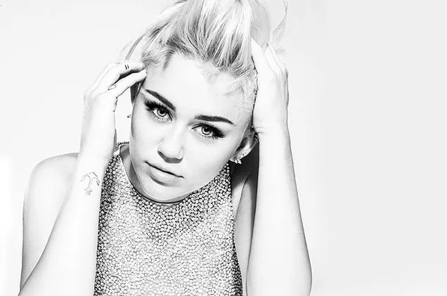 Η Miley Cyrus με κοντά ξανθά μαλλιά σε ασπρόμαυρη φωτογραφία.