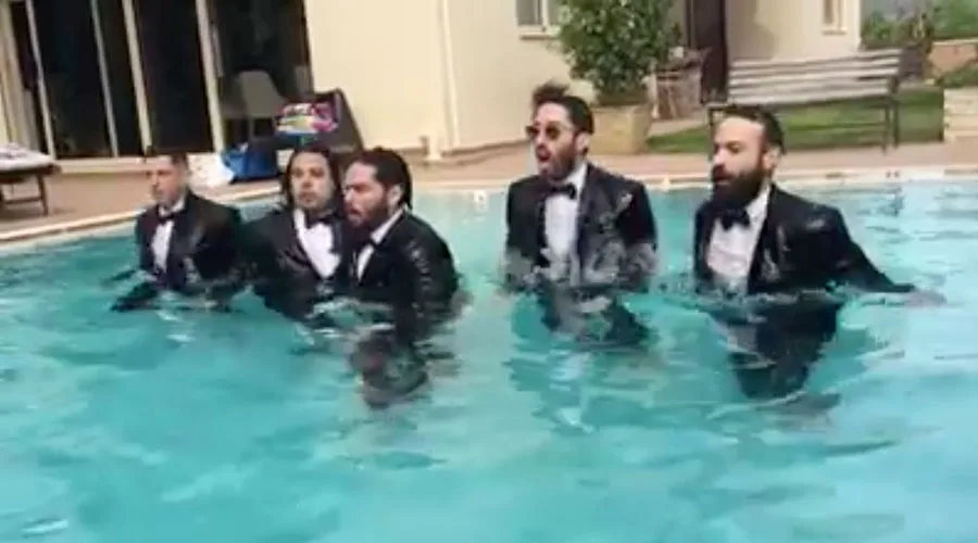 Το συγκρότημα ΜΕΛΙSSES μέσα σε μια πισίνα φορώντας κοστούμια.