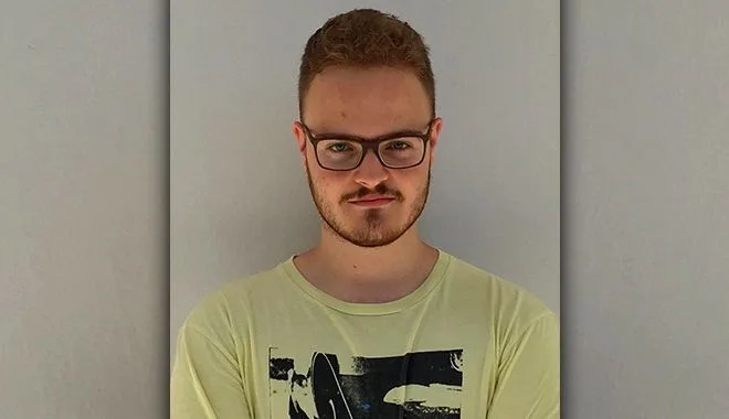 Νεαρός άνδρας με γυαλιά και κίτρινο t-shirt.