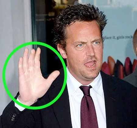 Ο Matthew Perry σε δημόσια εμφάνιση με το χέρι του σηκωμένο.
