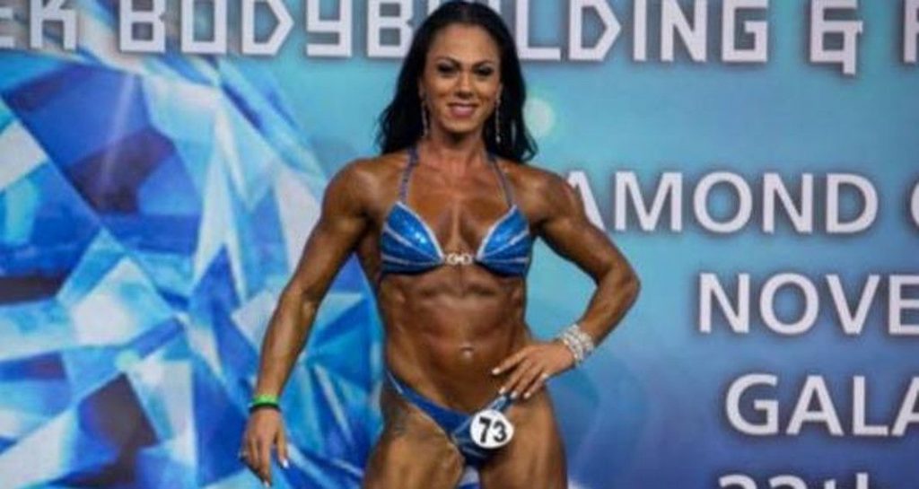 Γυναίκα bodybuilder σε διαγωνισμό με μπλε μπικίνι.