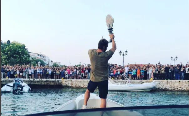 Ο Γιώργος Αγγελόπουλος (Ντάνος) σε σκάφος σηκώνει το τρόπαιο του Survivor μπροστά σε πλήθος κόσμου στη Σκιάθο.