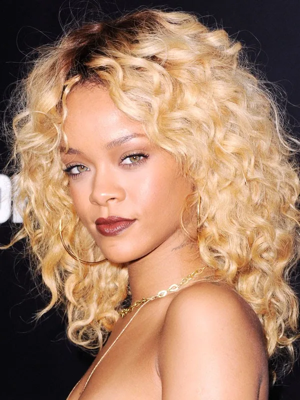 Η Rihanna με ξανθά σγουρά μαλλιά και σκούρο κραγιόν.