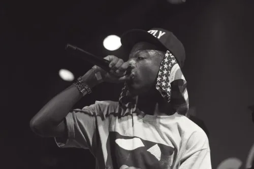 Ο ράπερ Joey Bada$$ στη σκηνή με μικρόφωνο.