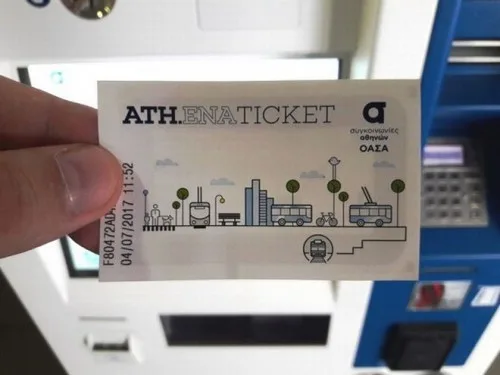 Εισιτήριο ATH.ENA TICKET του ΟΑΣΑ μπροστά από αυτόματο μηχάνημα έκδοσης.