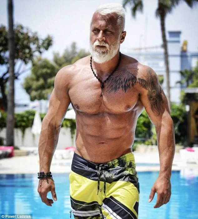Γυμνασμένος άνδρας με λευκά μαλλιά και γένια δίπλα σε πισίνα.
