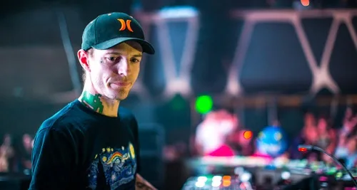 DJ με καπέλο και τατουάζ στο λαιμό σε εμφάνιση σε κλαμπ
