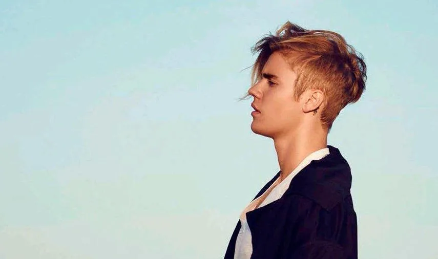 Ο Justin Bieber σε προφίλ με ξανθά μαλλιά και μαύρο σακάκι.