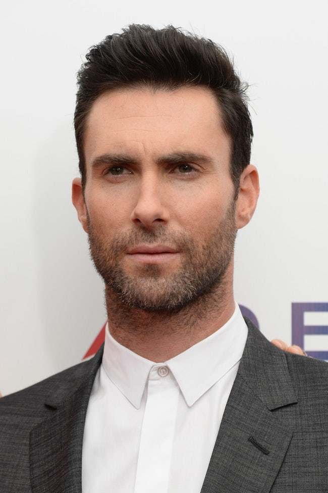 Ο Adam Levine με γκρι σακάκι και λευκό πουκάμισο.