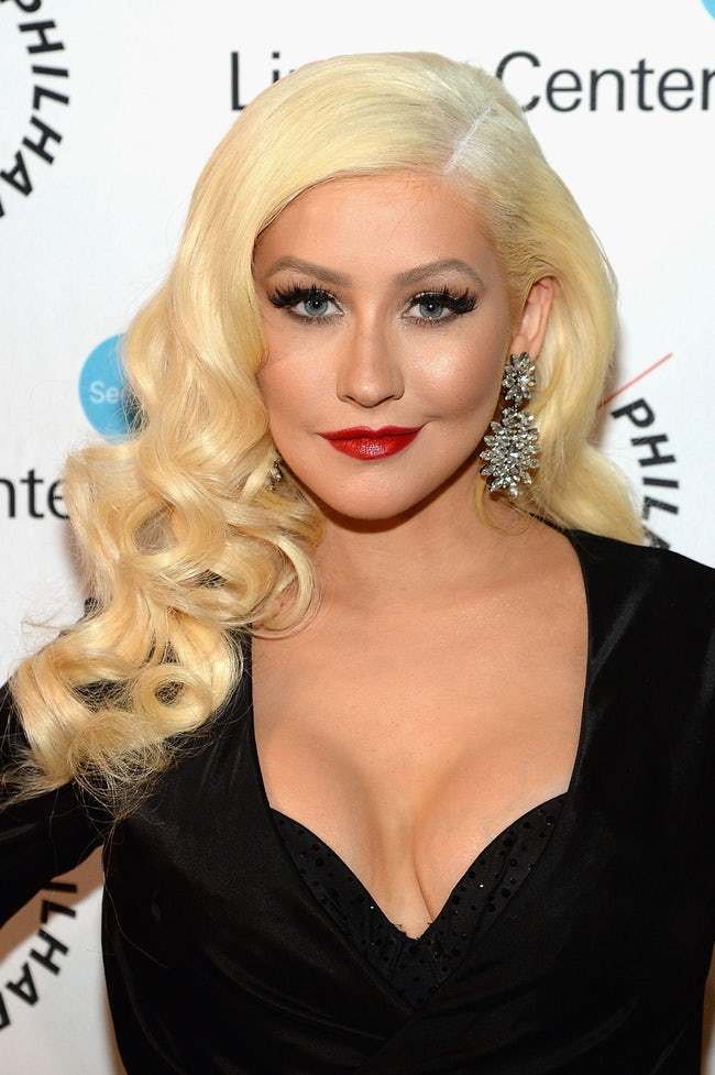 Η Christina Aguilera με ξανθά κυματιστά μαλλιά και κόκκινο κραγιόν.