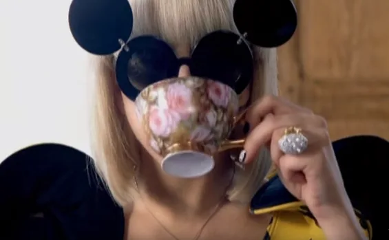 Η Lady Gaga με γυαλιά ηλίου Μίκυ Μάους πίνει τσάι στο video clip του Paparazzi.