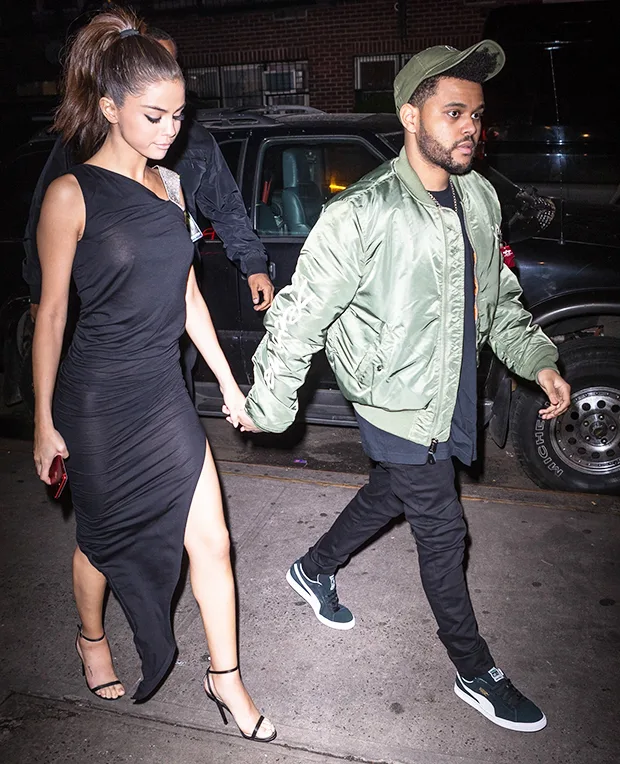 Η Selena Gomez και ο The Weeknd περπατούν πιασμένοι χέρι-χέρι στο δρόμο.