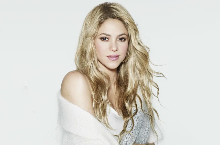 Η Shakira με ξανθά κυματιστά μαλλιά και λευκή ζακέτα.