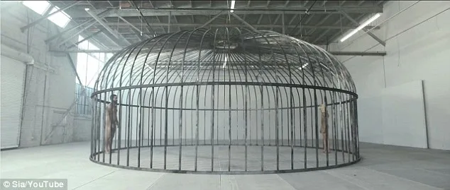 Σκηνή από το video clip Elastic Heart με δύο άτομα μέσα σε ένα τεράστιο μεταλλικό κλουβί.
