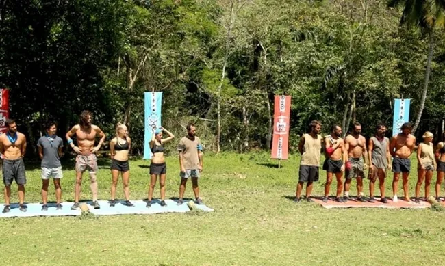 Παίκτες του Survivor σε υπαίθριο στίβο μάχης χωρισμένοι σε δύο ομάδες.