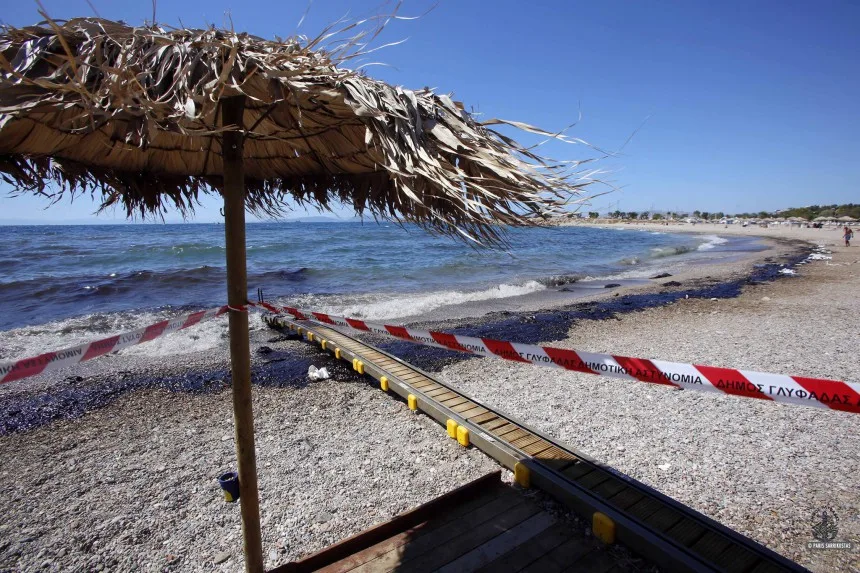 Παραλία στη Γλυφάδα με πετρελαιοκηλίδα και προστατευτική κορδέλα.