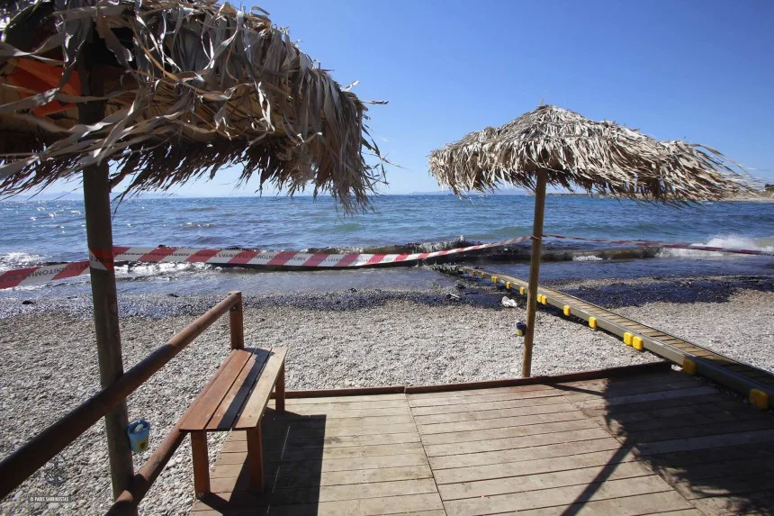 Παραλία με πετρελαιοκηλίδα και κορδέλα σήμανσης στη Γλυφάδα.