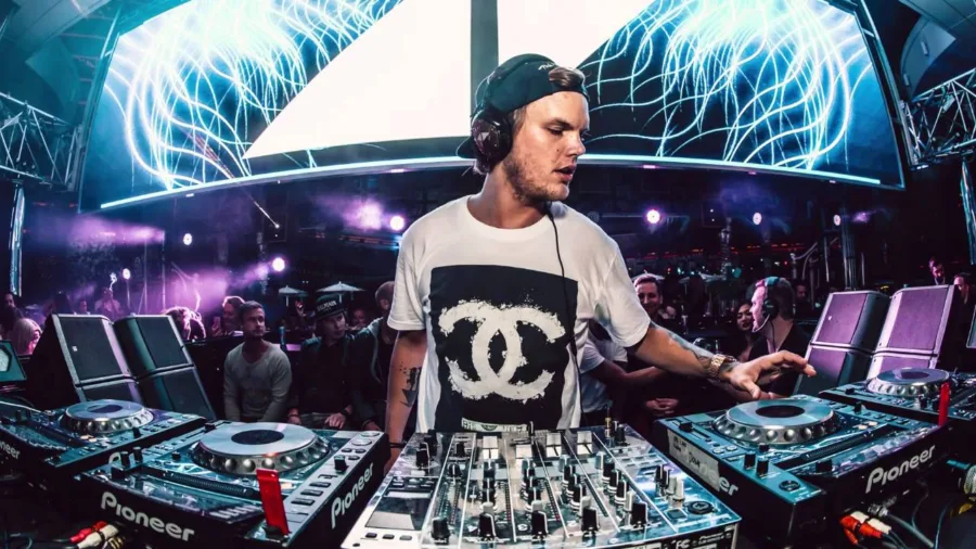 Ο Avicii σε DJ set με κονσόλα Pioneer και οθόνες στο παρασκήνιο.