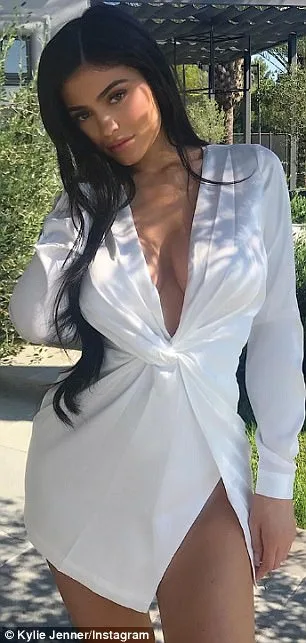Η Kylie Jenner ποζάρει σε εξωτερικό χώρο φορώντας λευκό μίνι φόρεμα.