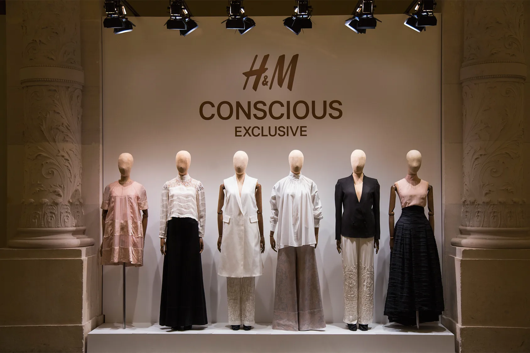 Έκθεση ρούχων H&M Conscious Exclusive με μανεκέν σε λευκό φόντο.