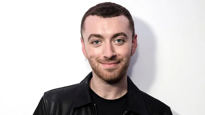 Ο Sam Smith σε κοντινό πλάνο με μαύρο δερμάτινο τζάκετ.