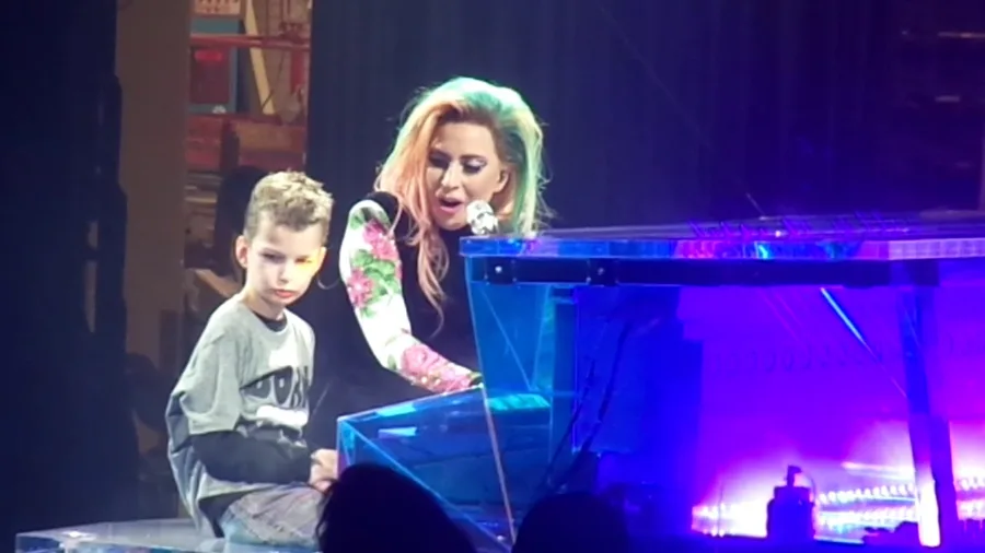 Η Lady Gaga στη σκηνή δίπλα σε ένα μικρό αγόρι στο πιάνο.