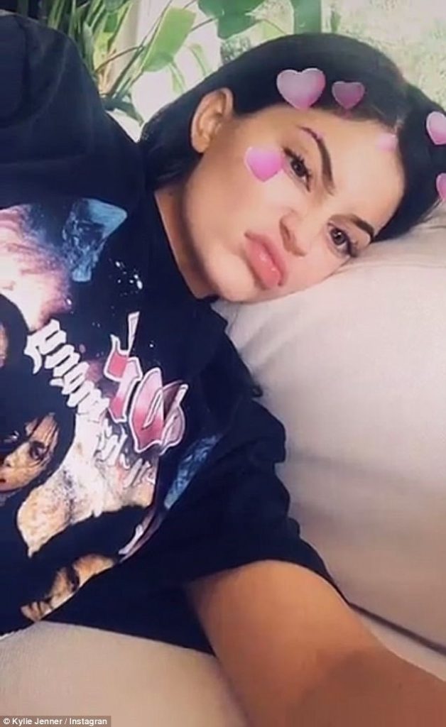 Η Kylie Jenner ξαπλωμένη με φίλτρο καρδιές στο πρόσωπο.