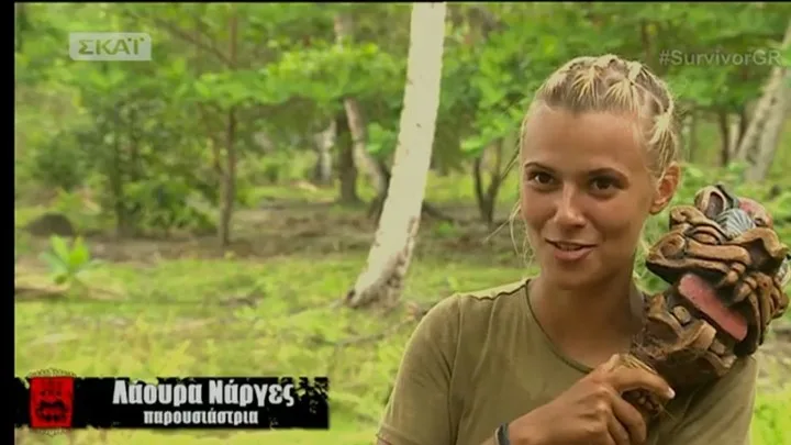 Η Λάουρα Νάργες στο Survivor κρατώντας ένα ξύλινο τοτέμ.