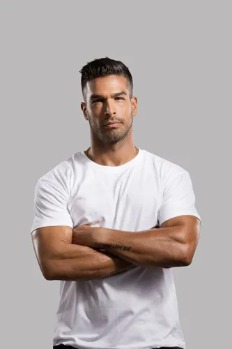 Άνδρας με λευκό t-shirt και σταυρωμένα χέρια σε γκρι φόντο.
