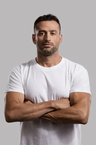 Πορτρέτο άνδρα με λευκό t-shirt και σταυρωμένα χέρια.