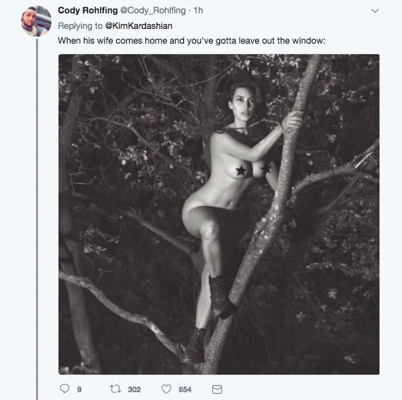 Η Kim Kardashian σκαρφαλωμένη σε δέντρο σε ασπρόμαυρη φωτογραφία.